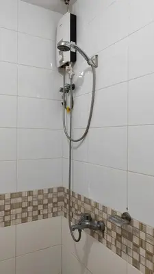 a shower with a shower head in a bathroom at V hotel paranaque in Manila