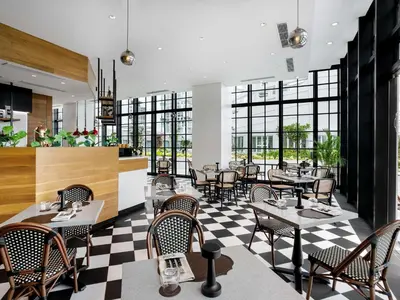 a restaurant with tables and chairs on a checkered floor at ibis Styles Manila Araneta City in Manila