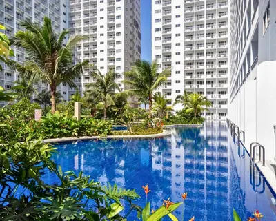 a swimming pool in a city with tall buildings at ndulge in opulence on a budget near MOA! Luxuriate in our Deluxe 1 Bedroom Units with stunning views. Enjoy free NETFLIX and an exceptional discount. Book now for a lavish and affordable escape! in Manila