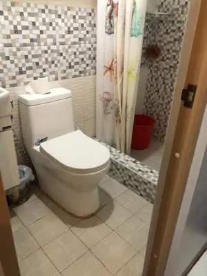 a bathroom with a toilet and a shower curtain at 1BR Condo Unit W/ Fantastic View near US Embassy in Manila