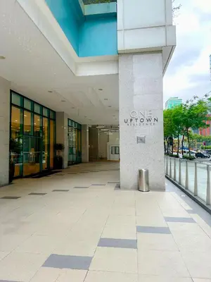 a building with the one university sign on it at 1 BR Uptown BGC Cozy Condo Netflix 200Mb Wi-Fi in Manila