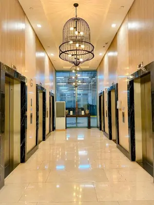 a hallway with lockers in a building with a chandelier at 1 BR Uptown BGC Cozy Condo Netflix 200Mb Wi-Fi in Manila