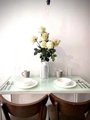 a table with two plates and a vase of roses at Nature Inspired Cozy Studio Rooms Mandaluyong Near Edsa Shaw Shangri-La Megamall at F Residences in Manila