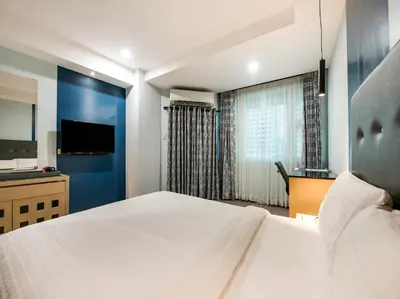 a bedroom with a large bed and a television at Homes at Bay Area Suites by SMS Hospitality in Manila