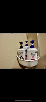 a shelf with three bottles of detergent on a wall at Apartment Seaside Bliss in Manila