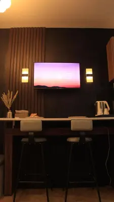 a bar with two stools and a tv on a wall at Avida Sucat Tower 9 in Manila