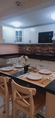 a kitchen with a table with plates and wine glasses at Saphir Townhouse 5 to 6 pax rooftop terrace, Cavite in Imus