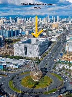 an aerial view of a city with a skyscraper at Aiza's Place in Shell Residences MOA in Manila