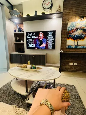 a person laying on a rug with their foot on a table at Aiza's Place in Shell Residences MOA in Manila