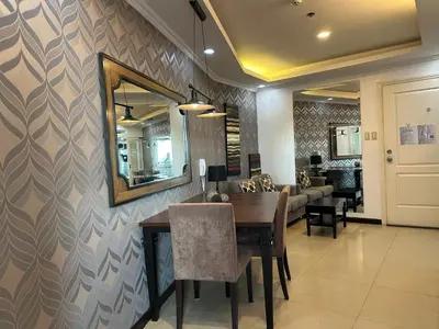 a dining room with a table and a mirror at Gramercy Residences 46th Floor 1 Bedroom Sunset View in Manila