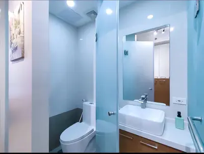 a bathroom with a toilet and a sink and a mirror at 1BR Condotel Suite at Sunshine100 City Plaza #SS01 in Manila