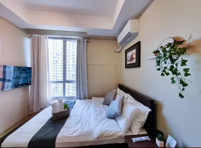 a bedroom with a large bed with a window at 1BR Condotel Suite at Sunshine100 City Plaza #SS01 in Manila