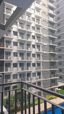 a large white apartment building with a swimming pool at JN Staycation at Shore 3 Mall of Asia in Manila