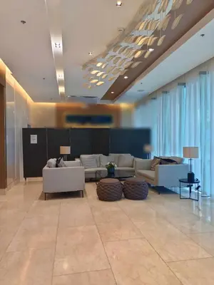 a lobby with couches and tables in a building at JN Staycation at Shore 3 Mall of Asia in Manila