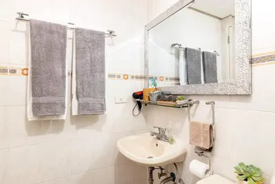 a white bathroom with a sink and a mirror at Executive Suite - BSA Twin Towers, Ortigas Ctr in Manila