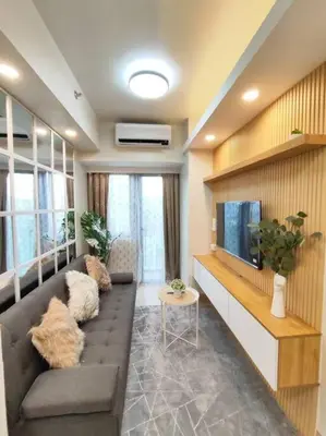 a living room with a couch and a flat screen tv at Scandi-Style & Organic condo Shore 3 MOA in Manila