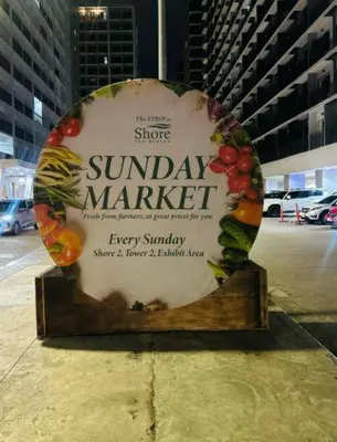 a sign for a sunday market with fruits and vegetables at Scandi-Style & Organic condo Shore 3 MOA in Manila