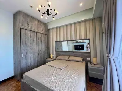 a bedroom with a large bed and a mirror at Penthouse Condo Unit near Airport NAIA in Manila