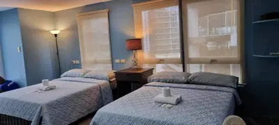 two beds in a room with blue walls at ADB AVENUE TOWER in Manila