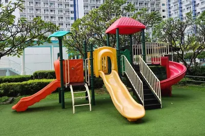 a playground with different types of slides in a park at Great View in Makati in Manila