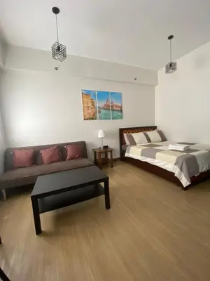 a large bedroom with a bed and a couch at Studio Type Condominum at SMDC HOPE Residences in Trece Martires
