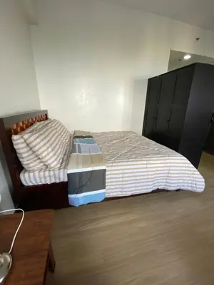 a bedroom with a bed with a black headboard at Studio Type Condominum at SMDC HOPE Residences in Trece Martires