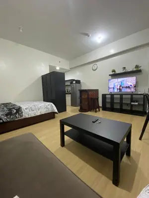 a living room with a bed and a coffee table at Studio Type Condominum at SMDC HOPE Residences in Trece Martires