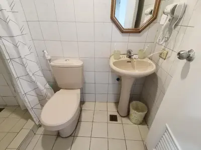 a bathroom with a toilet and a sink at citadel inn apartment in Manila