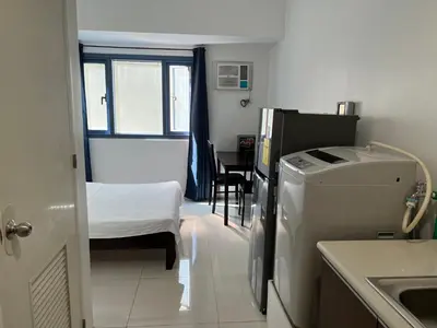 a small room with a refrigerator and a bed at Dreamy Sunset Bay in Manila