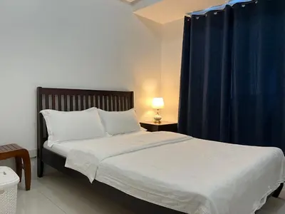 a bedroom with a bed with a blue curtain at Dreamy Sunset Bay in Manila