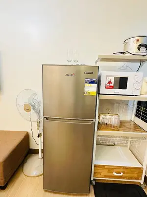 a metallic refrigerator in a kitchen with a microwave at Starlight Suites in Trece Martires