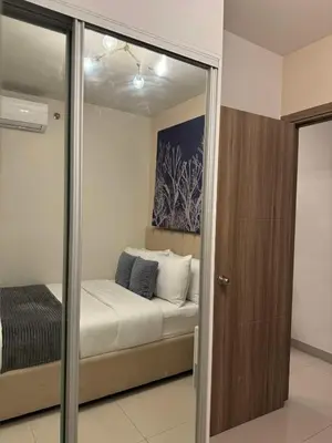 a bedroom with a bed and a mirror at Homefort at S Residences in Manila