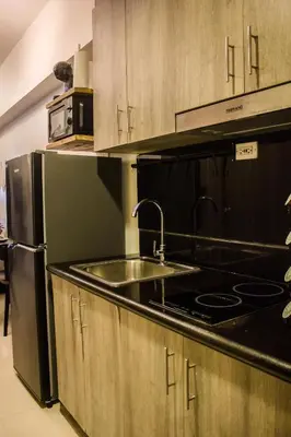 a kitchen with a sink and a refrigerator at RQ Cozy One Bedroom Condo, Coast Residences Pasay in Manila