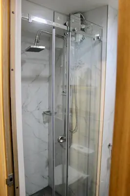 a shower with a glass door in a bathroom at RQ Cozy One Bedroom Condo, Coast Residences Pasay in Manila