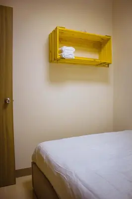 a room with a bed and a shelf on the wall at RQ Cozy One Bedroom Condo, Coast Residences Pasay in Manila