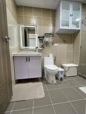 a bathroom with a toilet and a sink and a mirror at SMDC Coast Residences in Manila