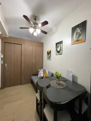 a dining room with a table and a ceiling fan at Hope Serenity, Spring Residences Tower 3 in Manila