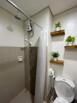 a bathroom with a shower and a toilet at Hope Serenity, Spring Residences Tower 3 in Manila