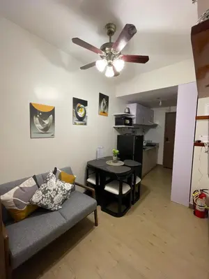 a living room with a couch and a ceiling fan at Hope Serenity, Spring Residences Tower 3 in Manila