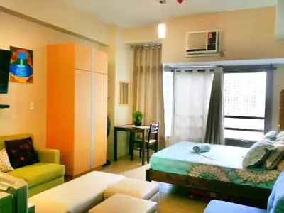 a bedroom with a bed and a couch and a chair at Studio-Type Condo at Eastwood Legrand 3 in Manila