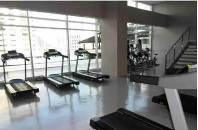 a gym with a row of treadmills in a building at The Beacon Makati in Manila