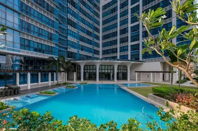 a large blue pool in front of a tall building at 1 BR with balcony in Uptown BGC in Manila