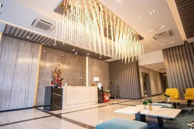 a lobby with a large chandelier and tables and chairs at 1 BR with balcony in Uptown BGC in Manila