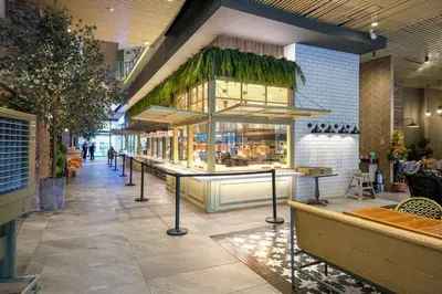 a restaurant with a counter in the middle of a building at Cozy 1BR with Balcony and Netflix in Uptown BGC in Manila