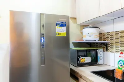 a stainless steel refrigerator in a kitchen with a microwave at A2J BGC Luxury 2BR Loft Near High Street, Airport in Manila