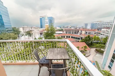 a balcony with a table and chairs and a city at Luxury Condo at Venice Mall near Airport, BGC & Makati in Manila
