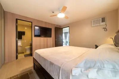 a bedroom with a large bed and a bathroom at Luxury Condo at Venice Mall near Airport, BGC & Makati in Manila