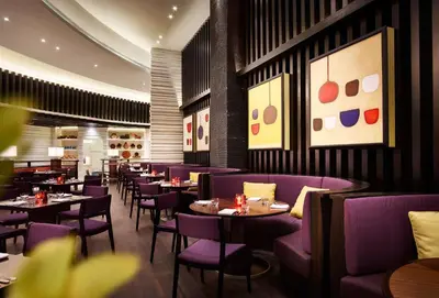 a restaurant with purple chairs and tables and paintings at Hyatt Regency Manila City of Dreams in Manila