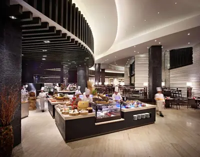 a restaurant with a buffet line with people in it at Hyatt Regency Manila City of Dreams in Manila
