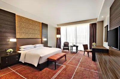 a hotel room with a bed and a television at Hyatt Regency Manila City of Dreams in Manila